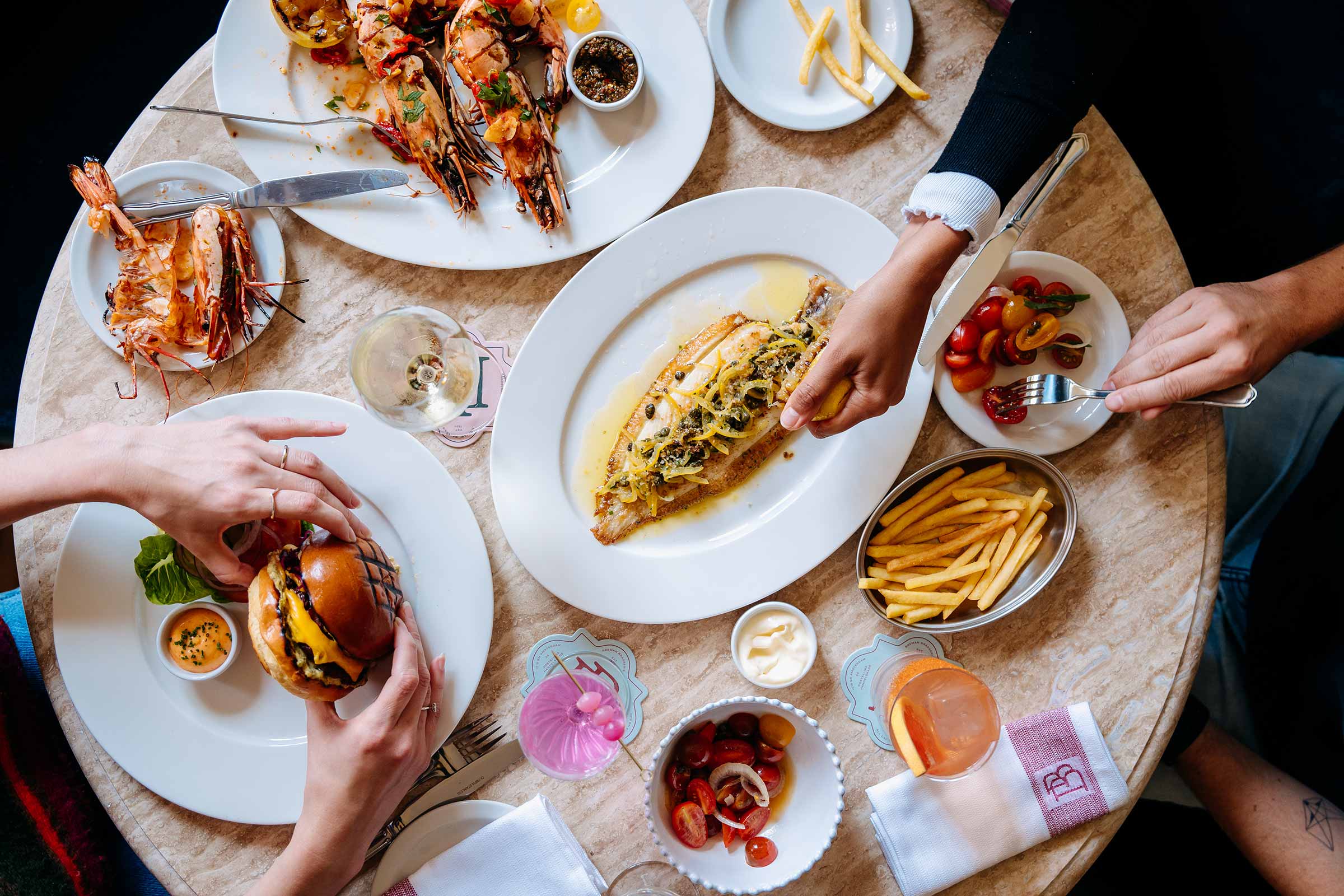 A round table full of delicious burgers and sandwiches with South American spices