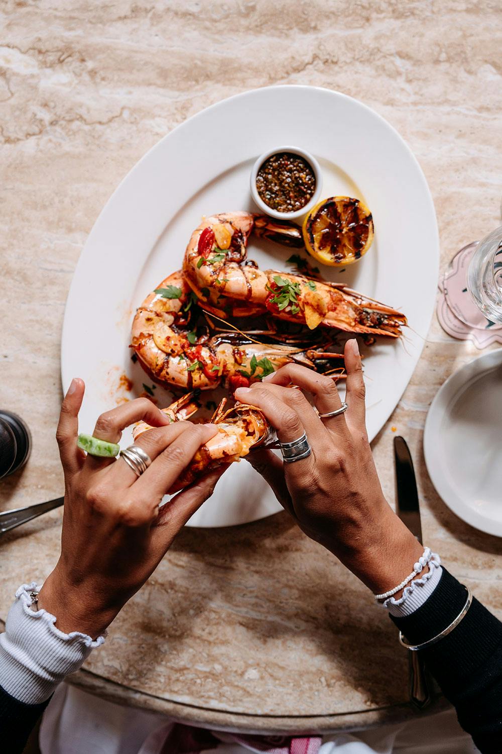 King prawns being shelled by two hands