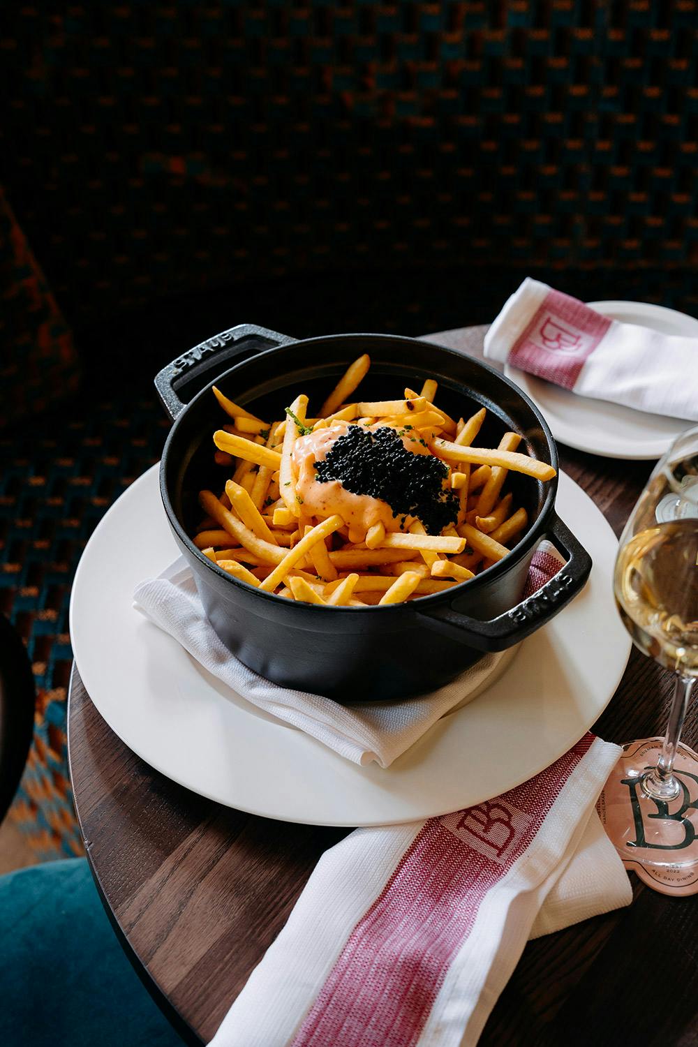 Iron dish of spicy chips served with white wine